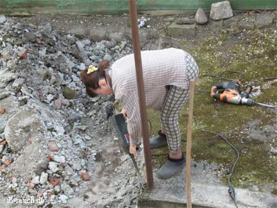 Nelia Sydoriak mit Bohrhammer Beton stemmen.