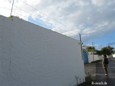 Mauer mit Stacheldraht und Glasscherben