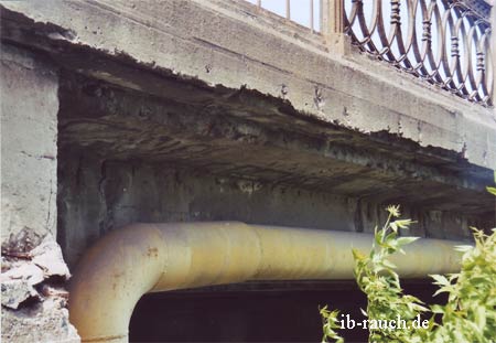 Auf der Unterseite der Brücke aus Beton fehlt bereits die Betonabdeckung. Das Bewährungseisen ist freigelegt.